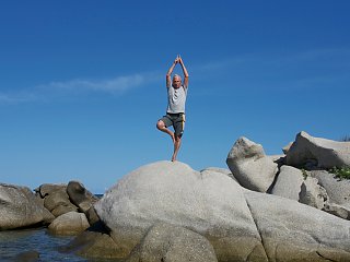 Yoga-Lehrer Werner Haas in der Baumposition am Meer von Sardinien