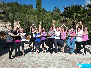 Die Gruppe genießt ihre Yogapraxis auf der Sonnenterrasse der Finca Son Mola Vell