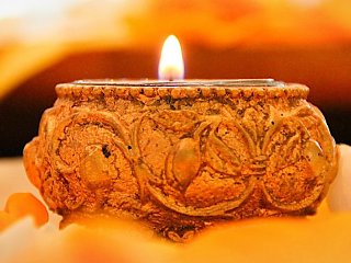 Der Strahl einer Kerze taucht seine Umgebung in ein warmes, weiches Licht