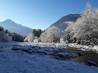 Verschneite Berglandschaften mit glitzernden Bächen & Bäumen um das Naturhotel Moosmair