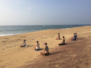 Die Reisegruppe von Kristin-Sybill Große bei einer Meditation am Strand in Kerala