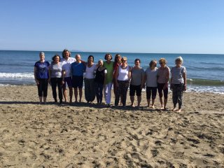 Die Yoga Gruppe genießt die letzten Sonnenstunden am Strand direkt vor der Tür