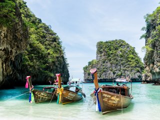 Die typischen geschmückten Boote in Thailands paradiesisch blau weißen Stränden