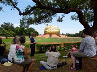 Reiseleiterin Lisa Thole mit einer Gruppe vor dem Matrimandir in Auroville