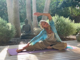 NEUE WEGE Yogalehrerin Andrea Ostheimer praktiziert Yoga vor einem Buddha