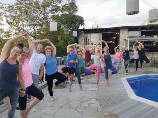 Mit strahlenden Gesichtern üben die Yogis am Pool des Cyprus Villages