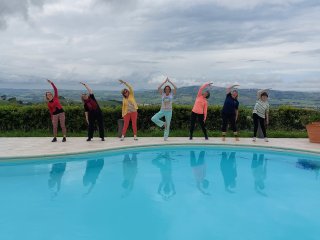 Yoga am Pool mit Aussicht auf die umliegende Natur