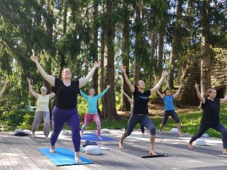 Üben Sie gemeinsam auf der Yoga-Plattform mitten im Grünen
