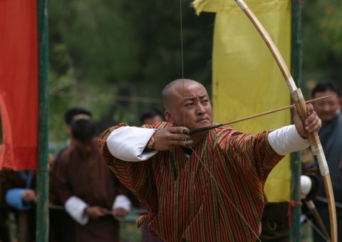 Mönche in Bhutan beim Bogenschießen 