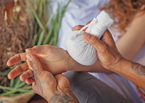 Bei einer ayurvedische Massage mit Kräuterstempel entspannen