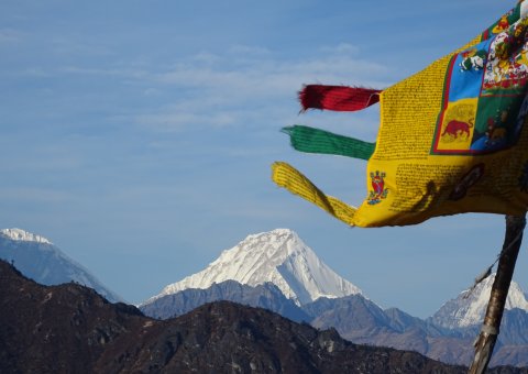 Hier scheint die Zeit still zu stehen: Wehende Fahne im Wind und schneebedeckte Berge