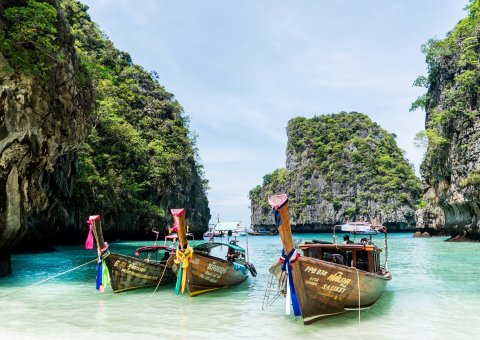 Die typischen geschmückten Boote in Thailands paradiesisch blau weißen Stränden