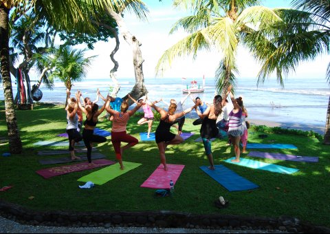 Yoga in der Gruppe am Strand von Bali 