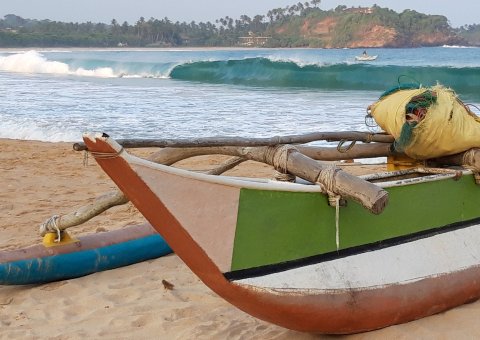 Entdecken Sie die kleinen traditionellen Holzboote am Strand von Sri Lanka 