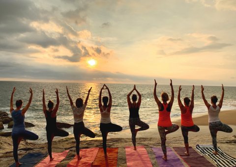 Yoga bei Sonnenaufgang mit Blick auf das Meer