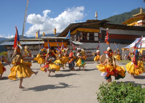 Bunte Trachten beim Tanz während des Dorf Festivals in Bumthang