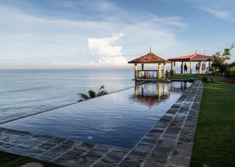Schwimmen Sie im Infinity Pool und blicken Sie dabei auf das Meer