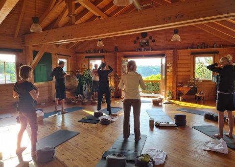 Gemeinsam mit Blick auf den See Yoga üben