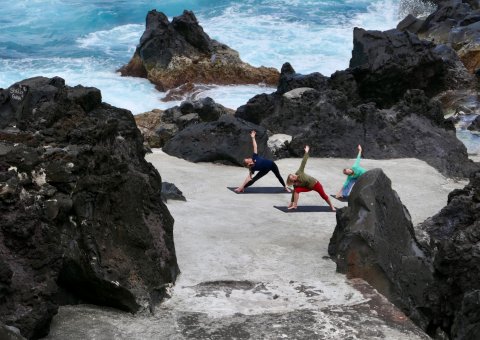Zusammen Yoga üben zwischen den Felsen der Azoren