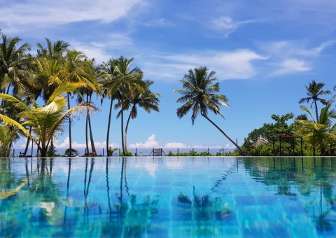 Auf den Liegen am Pool mit Blick auf das Meer entspannen