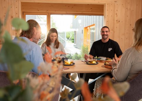 Mit anderen Gästen beim Essen zusammensitzen und austauschen